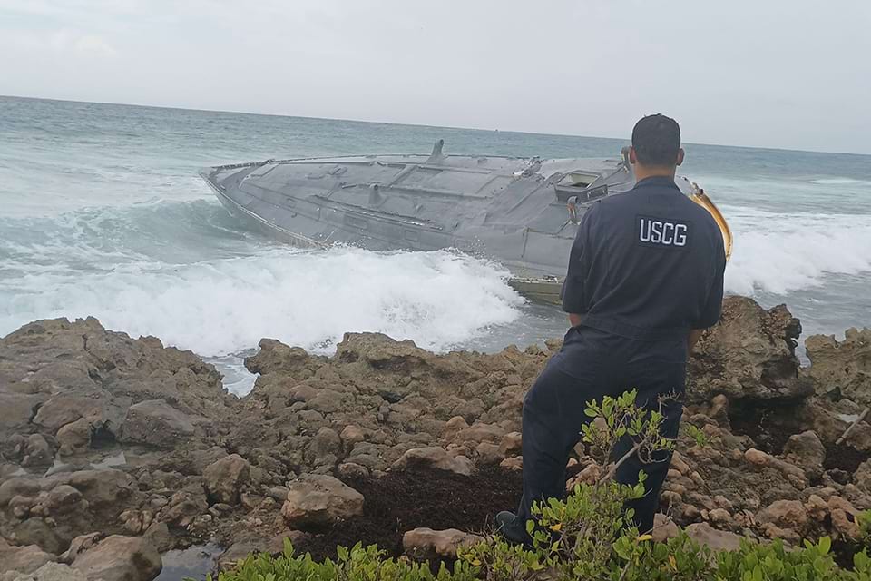 A Coast Guard Marine Science Technician inspects a derelict semi-submersible submarine on Mona Island, Puerto Rico. Image credit: USCG.