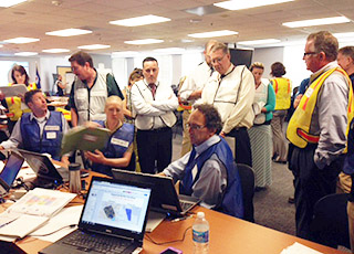 Photo of a group of NOAA employees observing data on computer screens
