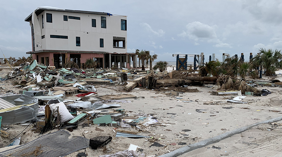 Debris and wreckage around a beach house.