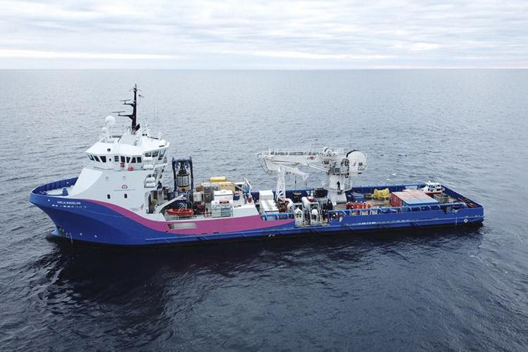 Blue, pink, and white U.S. Coast Guard ship on water.