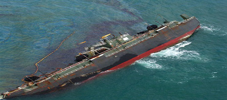 A disabled tank barge vessel in the Gulf of Mexico, showing a discharge of oil.