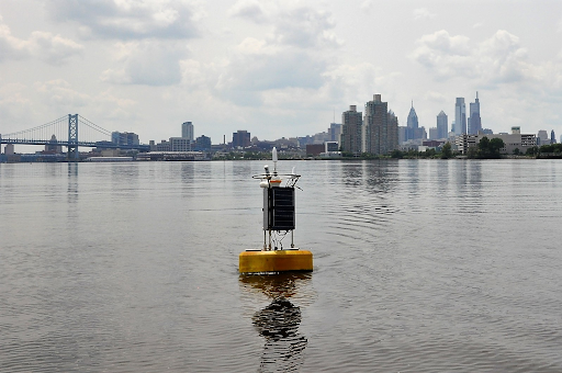 NOAA’s Currents Real-time Buoy (CURBY) deployed in the Delaware Bay sits against the backdrop of the Philadelphia skyline. Credit: NOAA