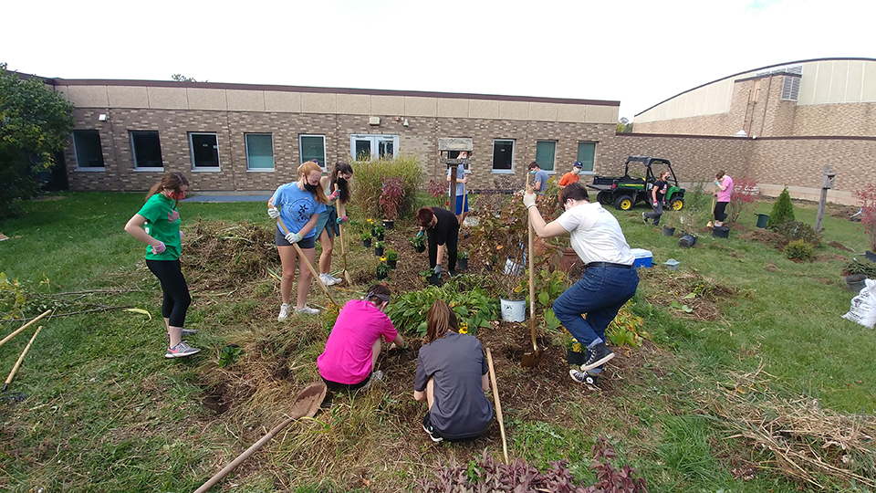Students working hard preparing the courtyard for planting of shrubs and trees.
