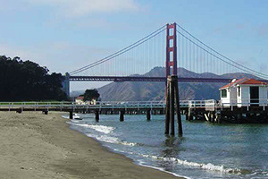 A sandy shoreline with a bridge in the distance