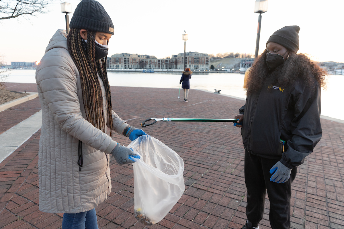 Henry Hall Fellows picking up trash on Baltimore harbor piers.