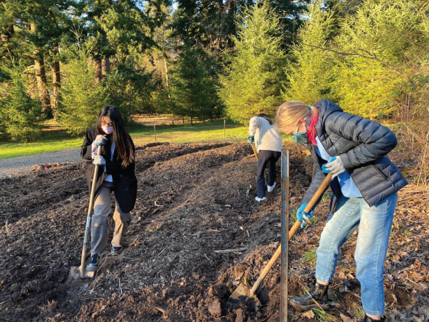 Members of the Catlin Gabel School Environment Action Team student group turn over the soil before planting. Loose soil is vital for quick growth in Tiny Forests.