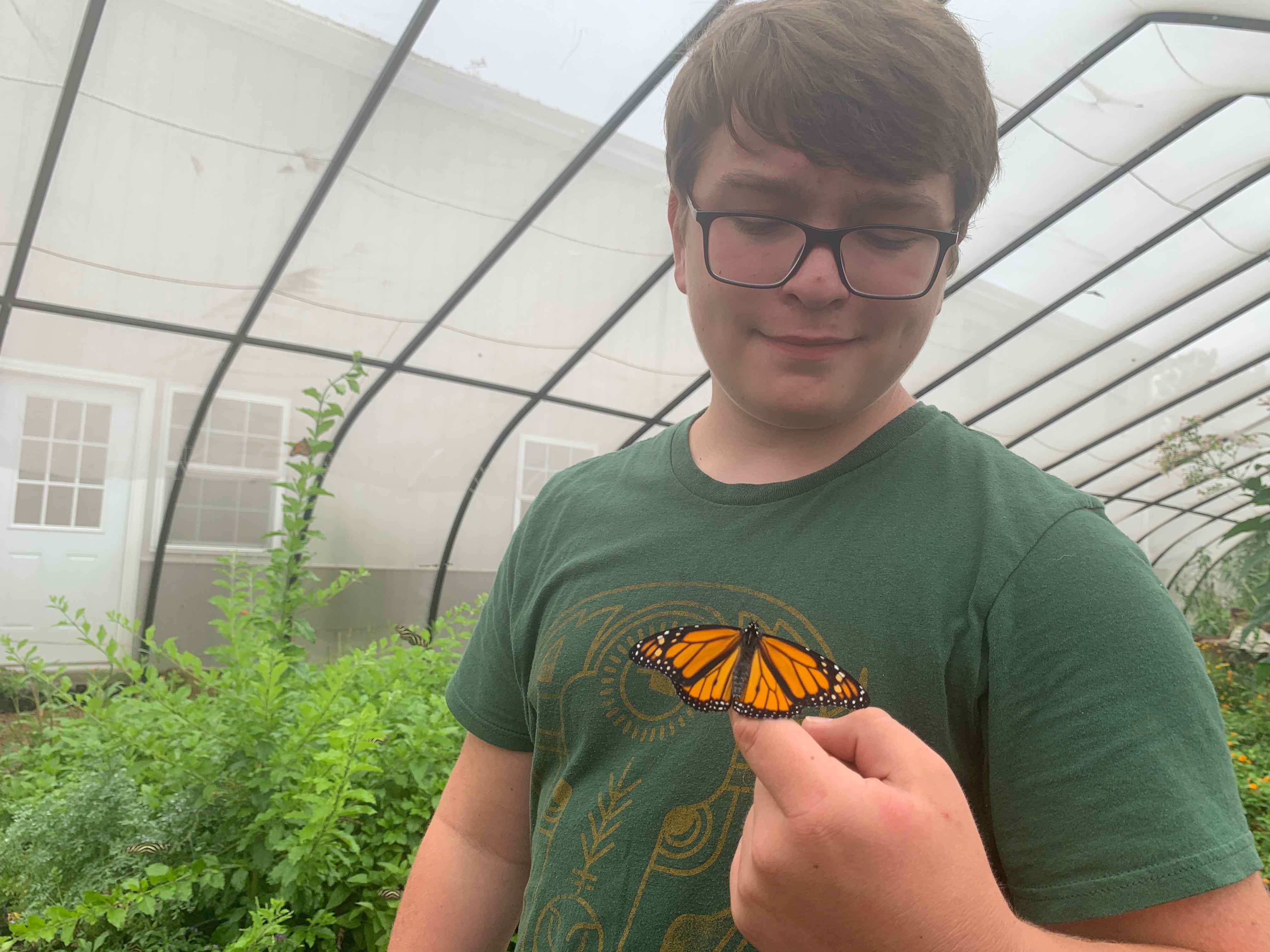Monarch butterfly lands on student at Tribal Alliance for Pollinators Euchee Butterfly Farm.