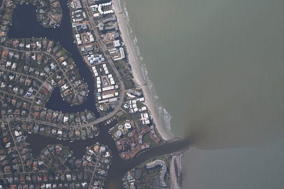 an aerial view of an estuary showing runoff in the ocean