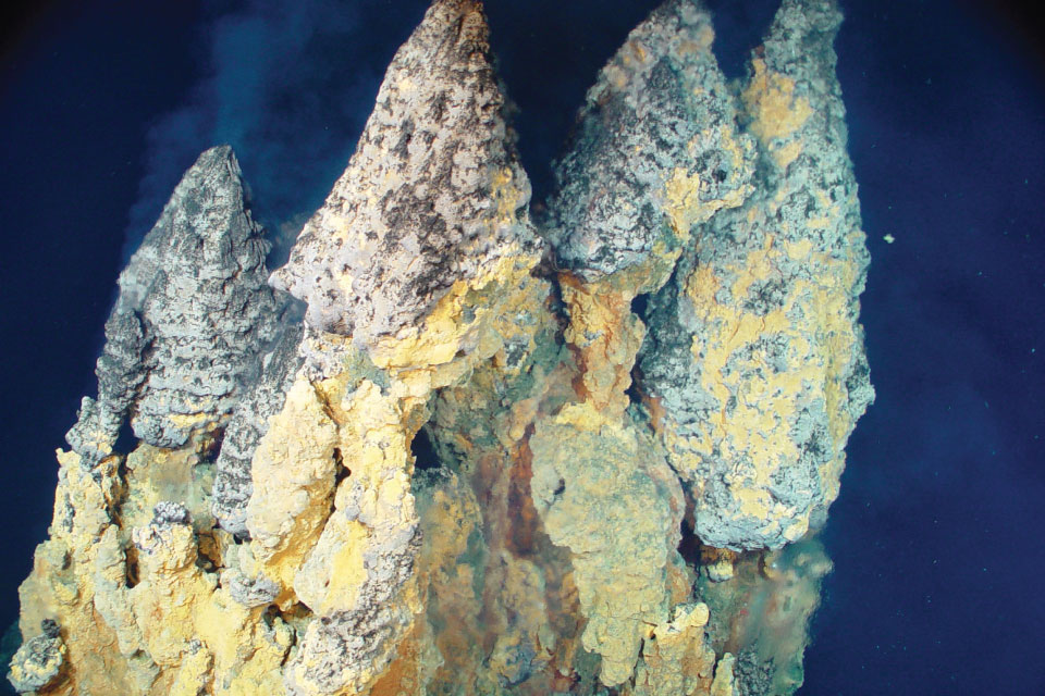 Active hydrothermal vents with yellows and dark patterns actively releasing plumes into the surrounding water.