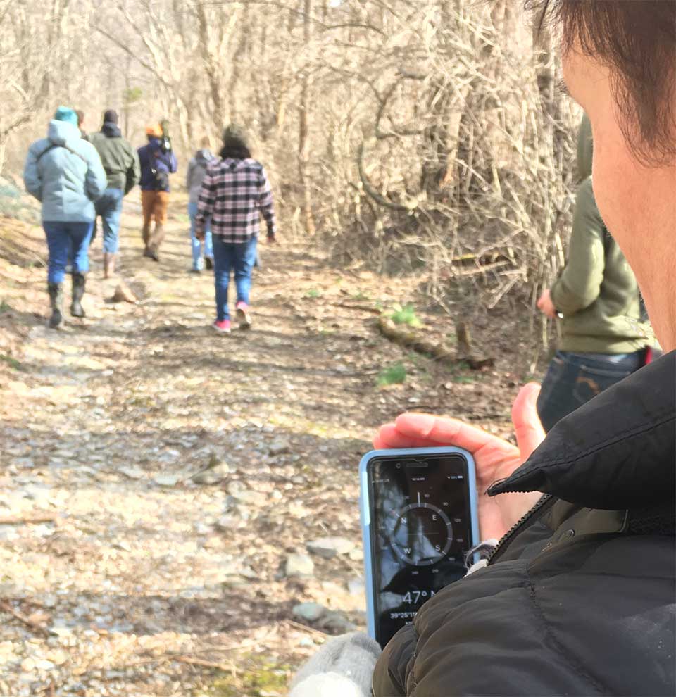a person uses a smartphone to look at coordinates on a hike