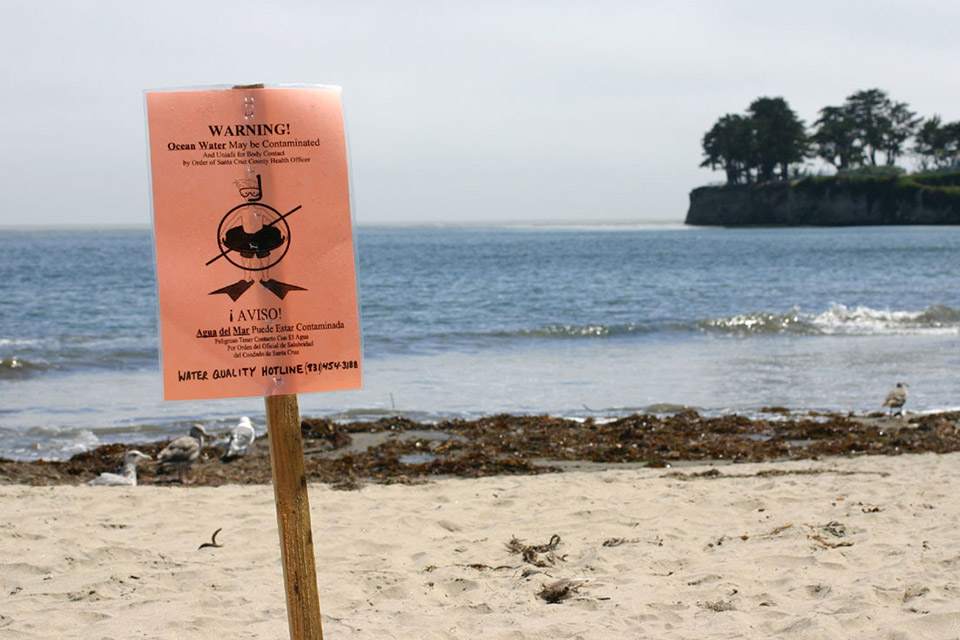 Ocean water contamination warning sign on the beach
