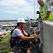 Staff from the Center for Operational Oceanographic Products and Services install a microwave radar water level sensor on the Dog River Bridge in Mobile County, Ala.