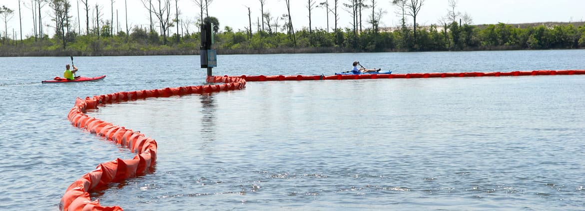 Kayakers at Naval Air Station Pensacola detour around oil containment boom on base at Sherman Cove , Pensacola, Florida, on May 4, 2010. The boom was set to protect environmentally sensitive grass beds from the Deepwater Horizon oil spill. Credit: U.S. Department of Defense 