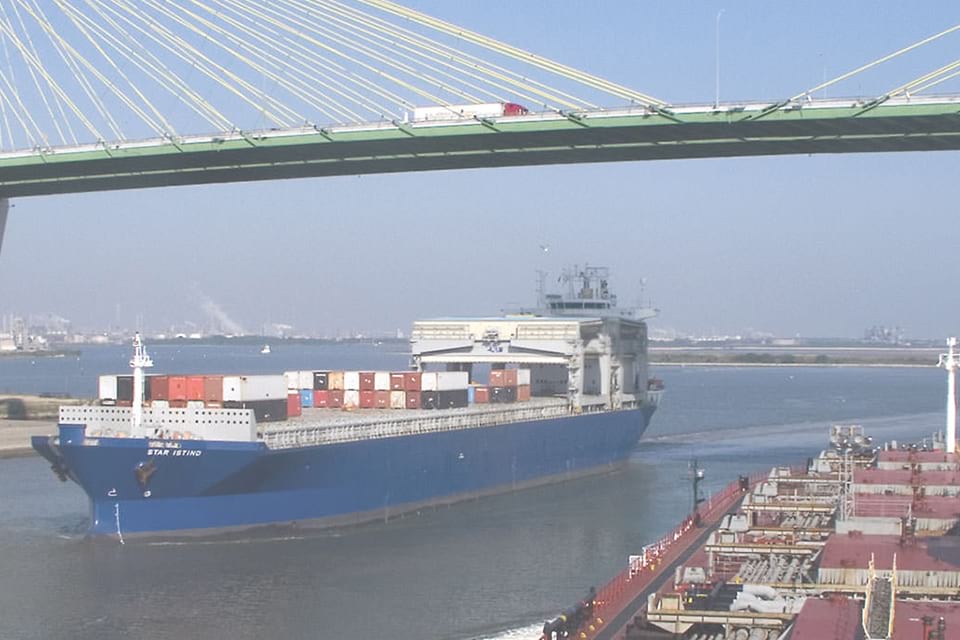 a shipping vessel going under a bridge