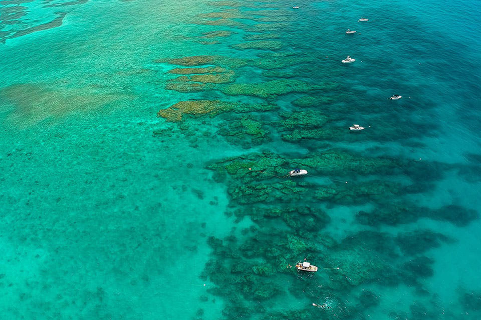 aerial view of Florida Keys ocean with coral reefs visible and scattered boats