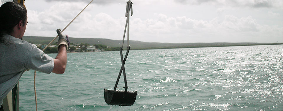 scientist collecting sediment samples from a boat in Guanica Bay, Puerto Rico