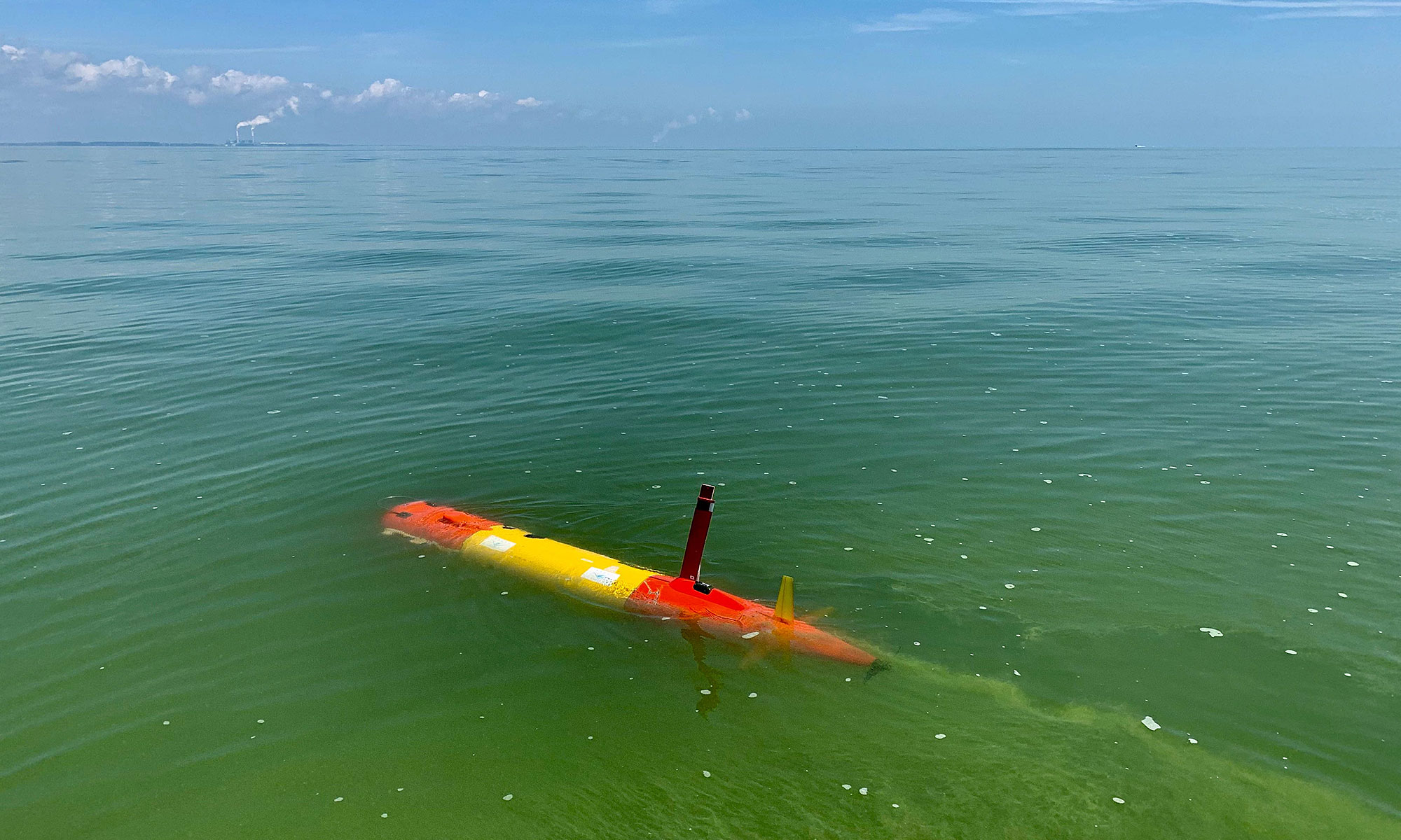 long-range autonomous underwater vehicles makes its way through the green, algae-rich waters of Lake Erie