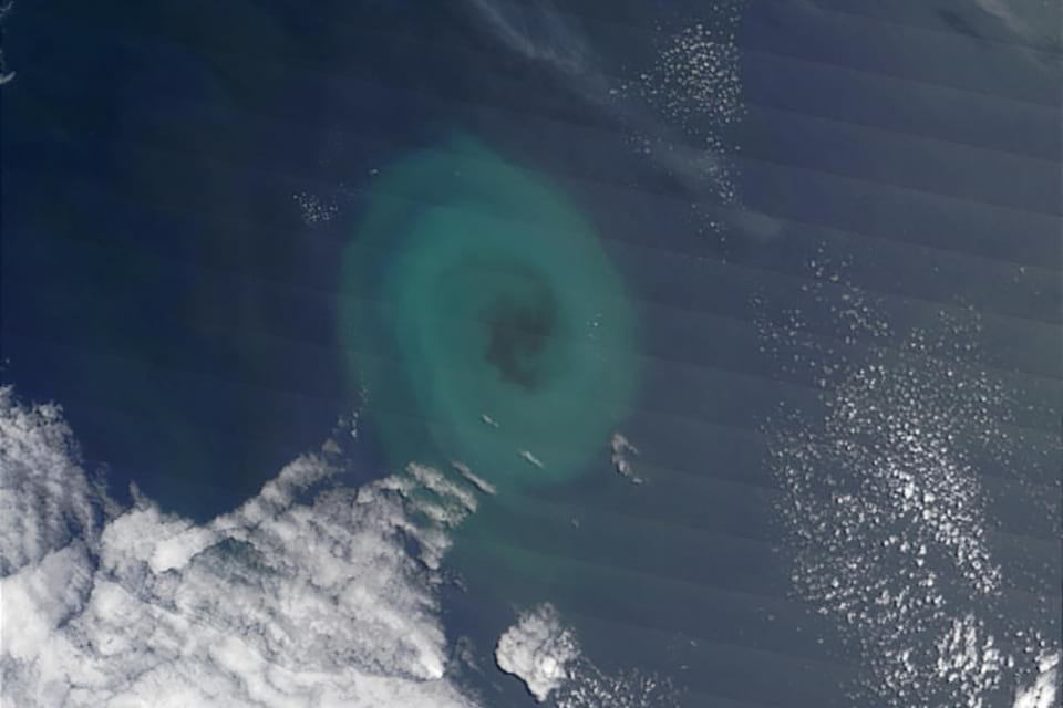 Photo of phytoplankton, which are microscopic marine organisms that use photosynthesis to create energy, that appear to be caught in a whirlpool, which causes them to swirl in a clockwise pattern.