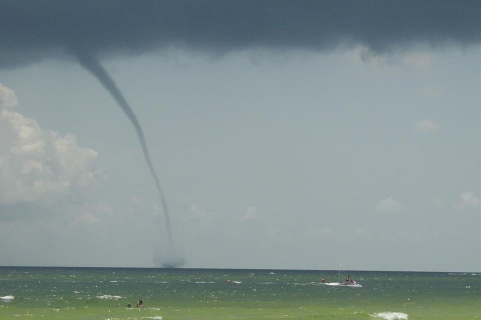 Photo of a waterspout close to a beach