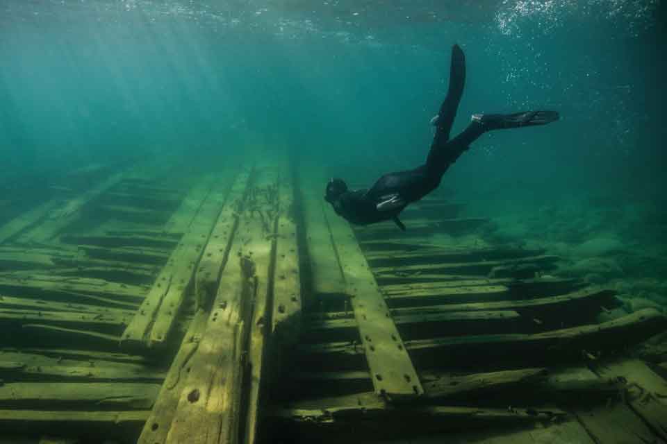 A snorkeler explores the shallow site of the sunken schooner Portland, lost in a Lake Huron storm in 1877. Credit: David Ruck.