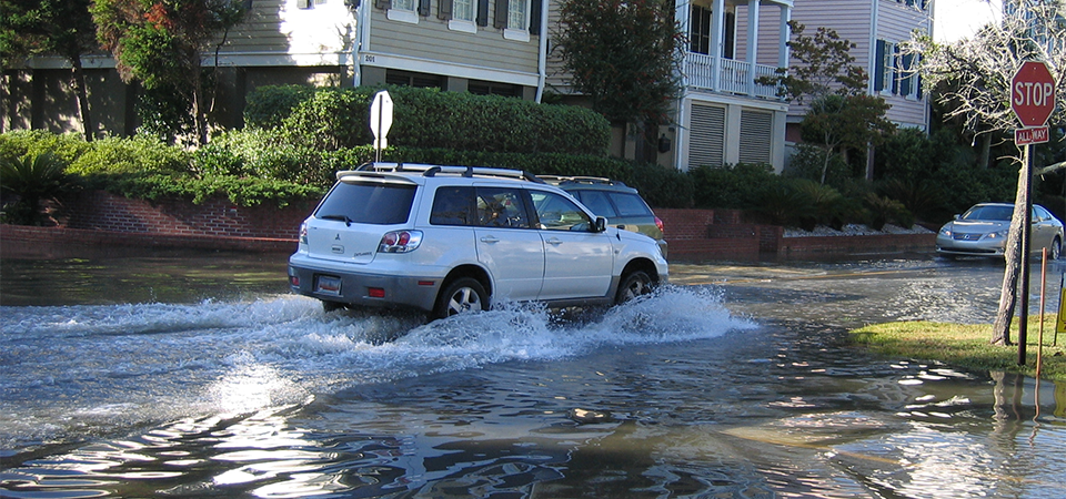 car drives on flooded street in Charleston, South Carolina