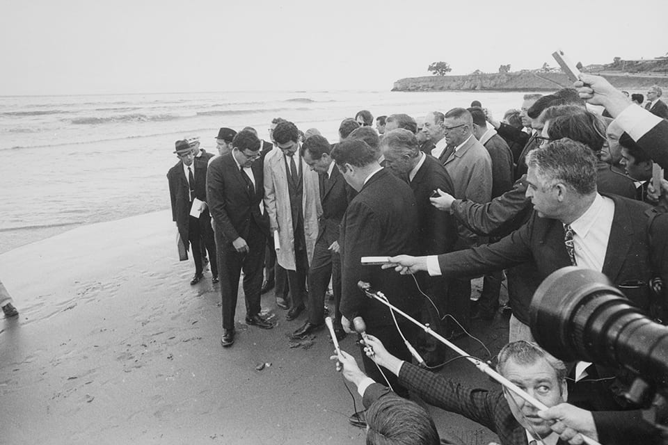 President Nixon and the press corps tour an oiled beach in Santa Barbara in 1969